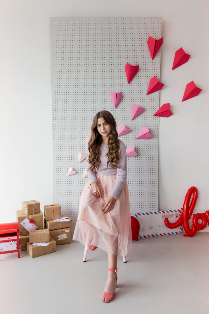 Valentine's Day photo shoot inspiration featuring paper airplane backdrop and love letters