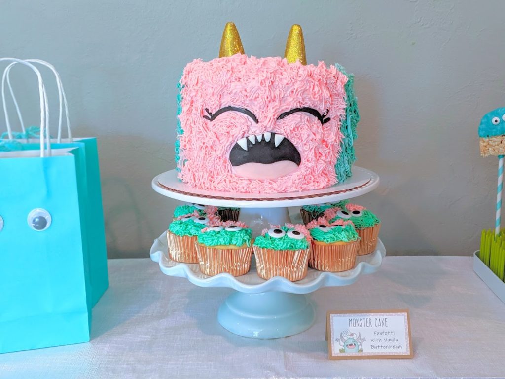 Pink and turquoise monster cake and monster cupcakes on cake stand baked by Sweet Condesa Pastries.