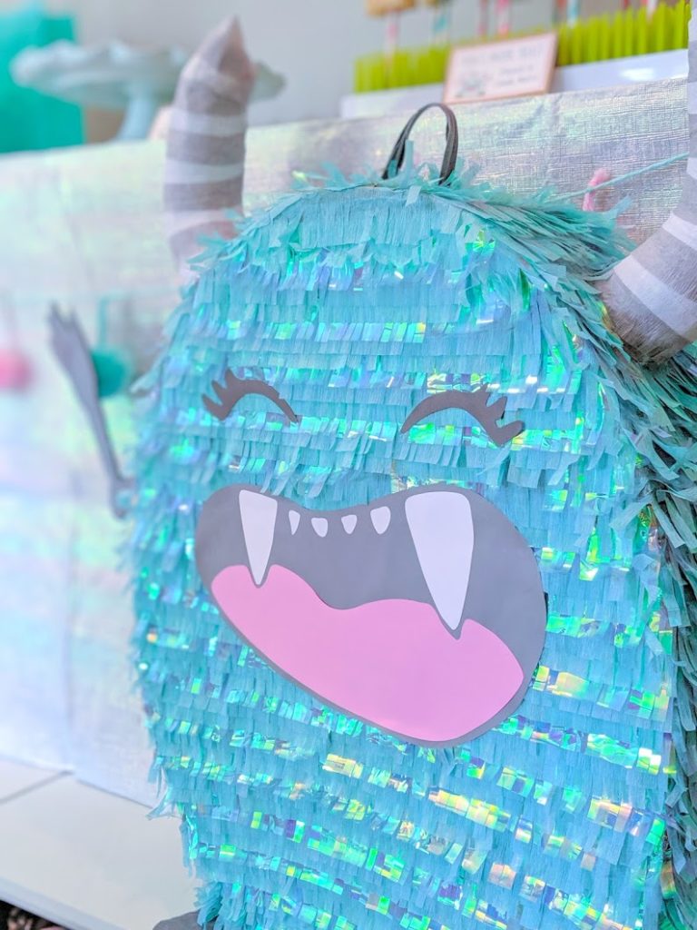 Terrible Twos Monster Pinata made with turquoise streamers and iridescent cellophane.