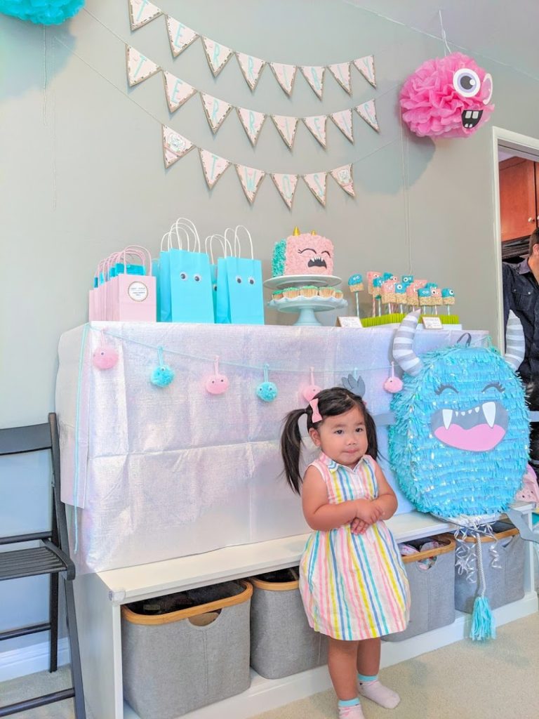 Birthday girl standing in front of Terrible Twos Birthday Party Dessert Table