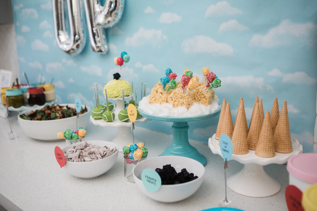 Dessert display featuring rice krispie treats, cake pops, puppy chow, ice cream cones