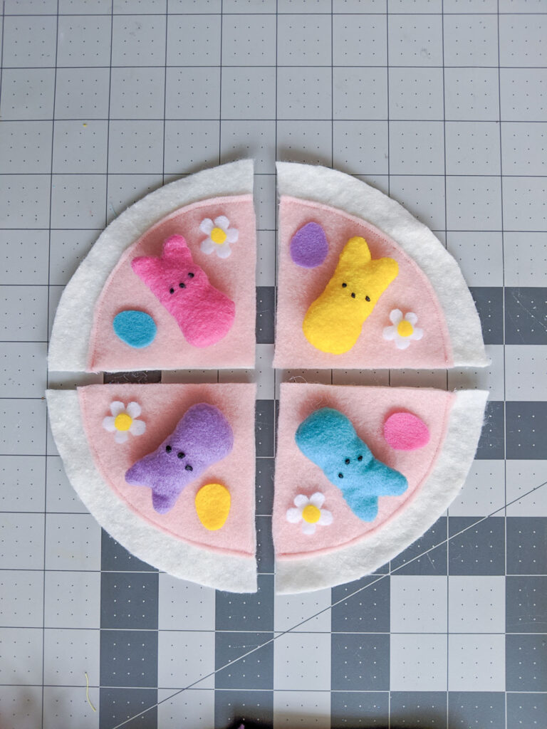 Felt Peeps bunnies and egg and flower toppings are placed on top of the pizza.