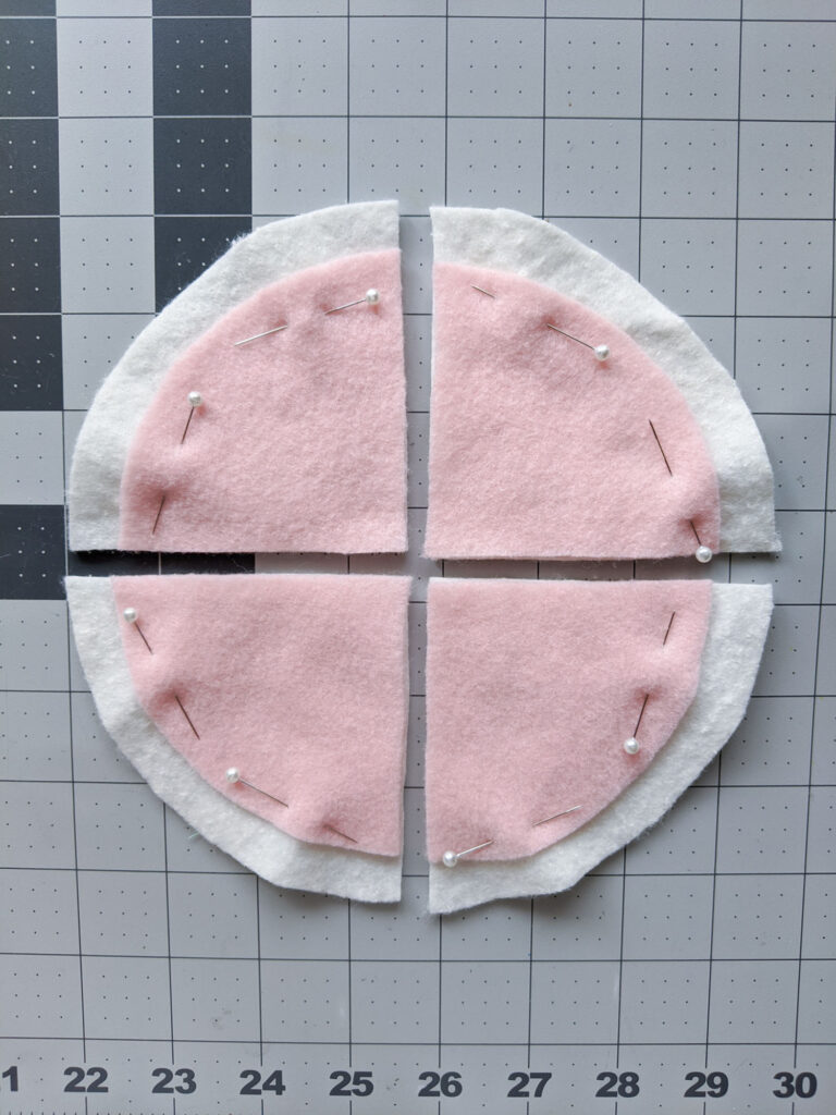 Pinning pink felt (the sauce) to off-white pizza slices.