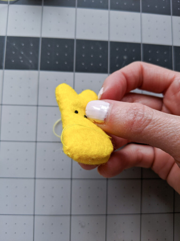 Closing the opening of the Peeps bunny by hand stitching it.