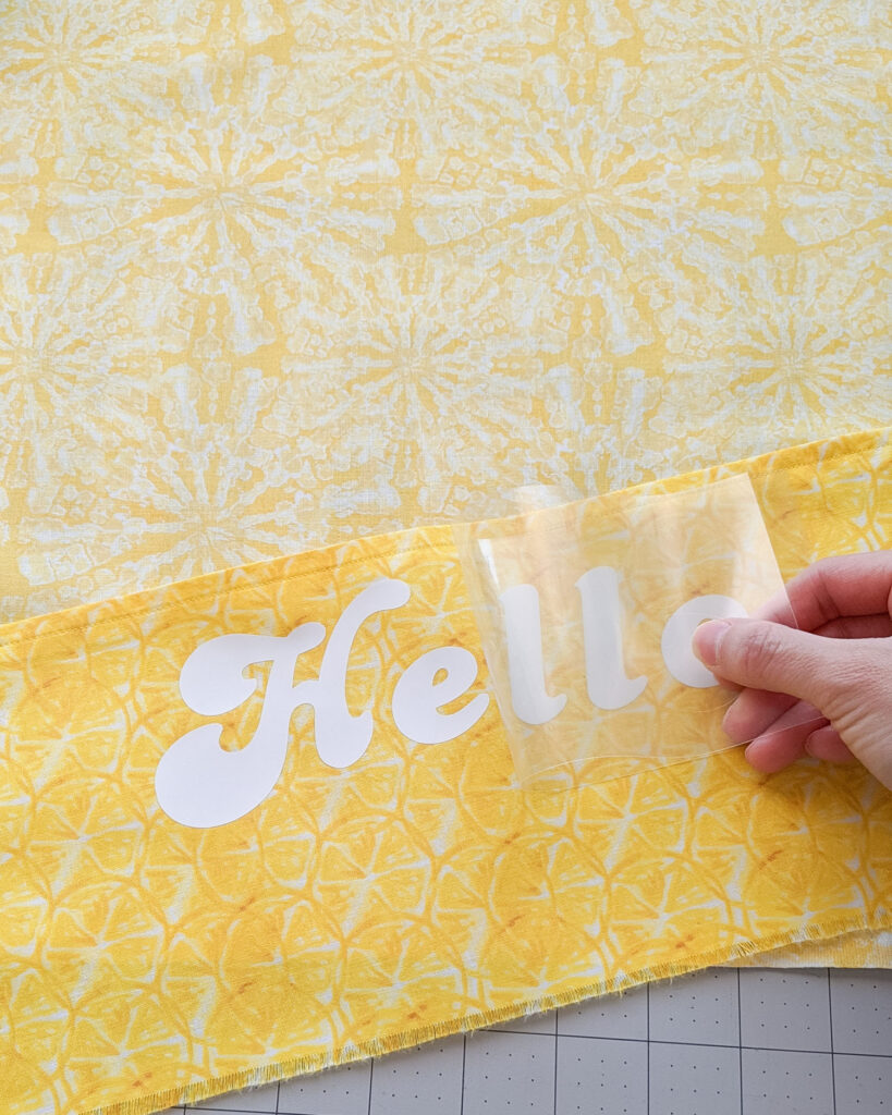 Peeling off liner from Cricut Smart Iron-On "Hello" design.