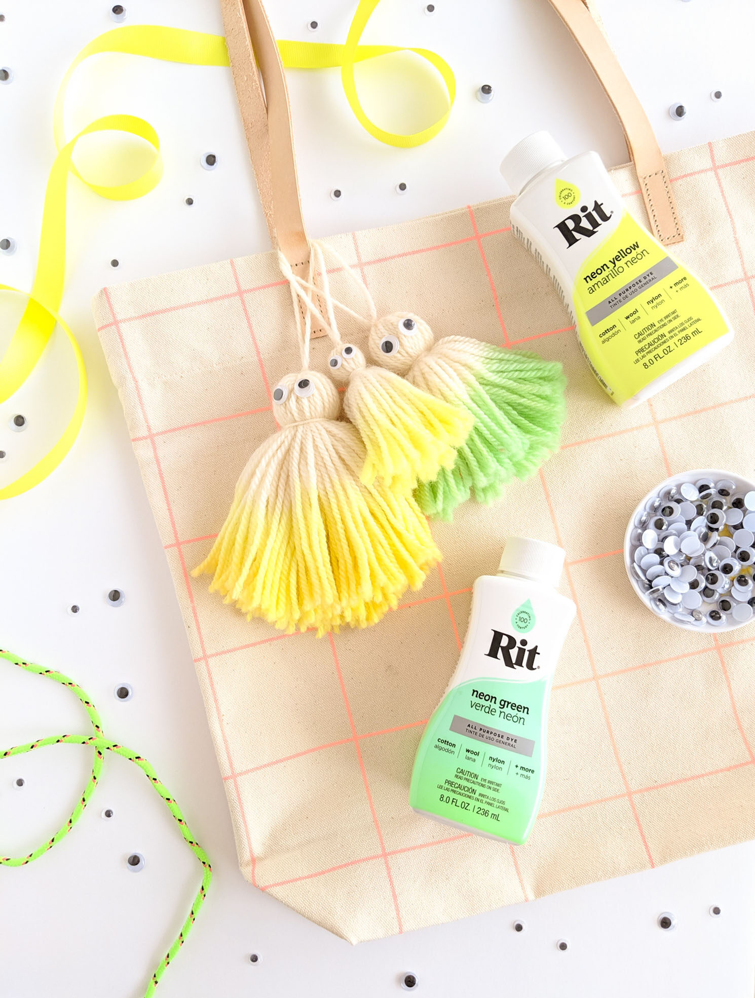 Dip dyed ghost tassels dipped in neon yellow and green hanging on a canvas tote bag