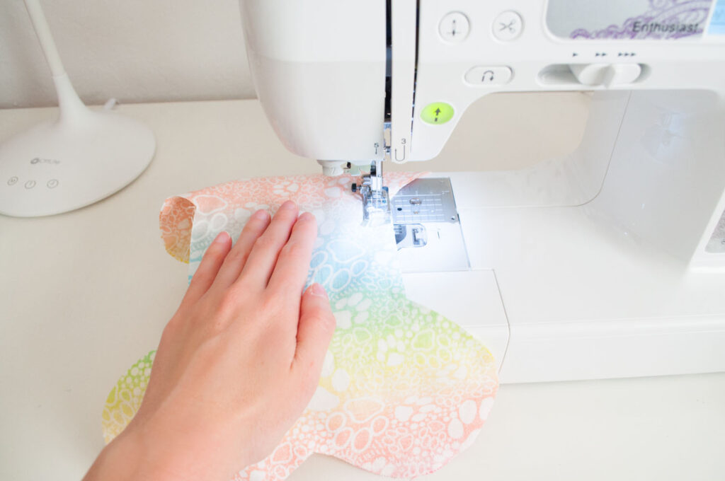 Blaire from Freshly Fuji is sewing around the the dog bone pillow.