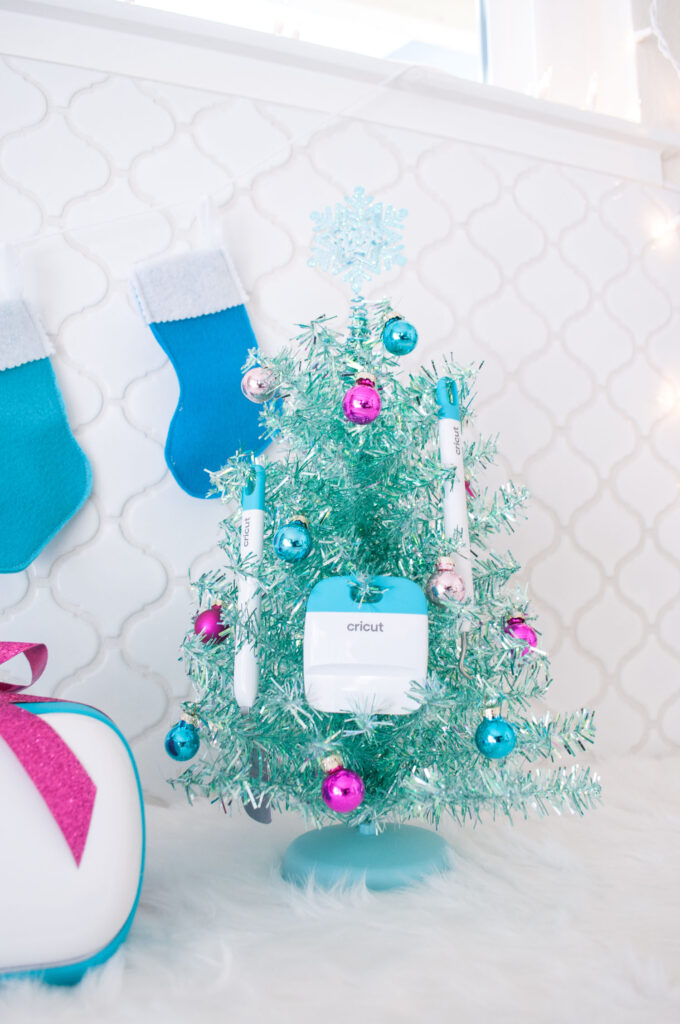 Close up of aqua Christmas tree with Cricut Joy tools and mini ornaments hanging from it.