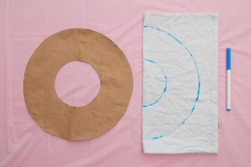 Photo showing how to tracing wreath shape onto white pillow cover.