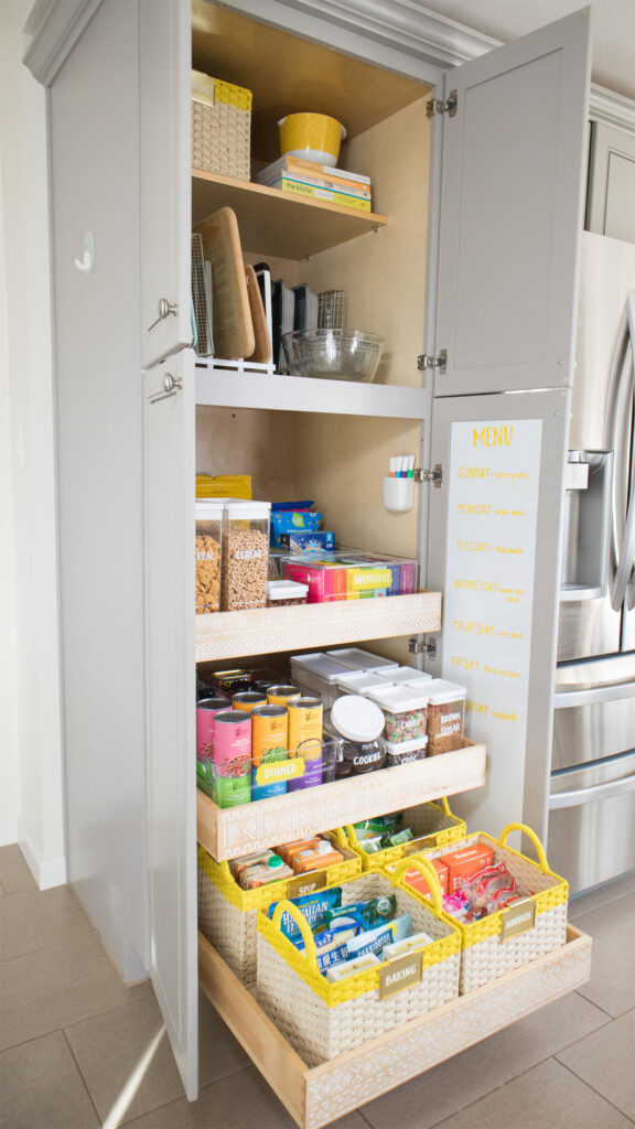 Finished pantry organization makeover. Side view of Blaire's pantry with drawers pulled out. You can also see the whiteboard attached to the inside cabinet door and the marker caddy mounted inside the cabinet.