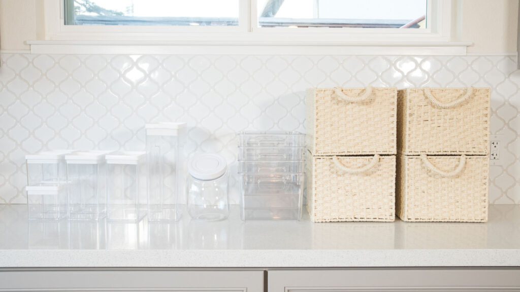 Storage items used for pantry organization project. Includes clear containers, clear plastic bins and woven baskets.