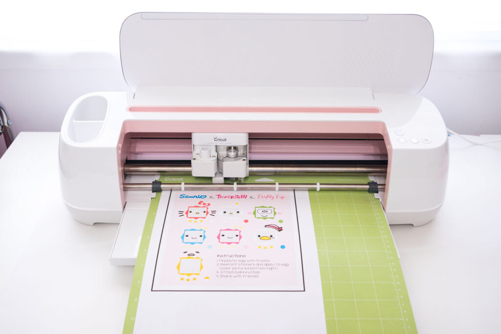 Sanrio x Tamagotchi x Freshly Fuji sticker sheet placed on a cutting mat and loaded into the Cricut Maker.