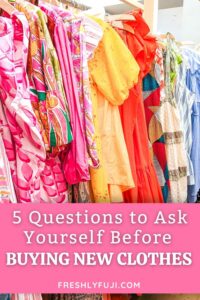 Rack of colorful clothes with text that says "5 Questions to Ask Yourself Before Buying New Clothes". Image for Pinterest.