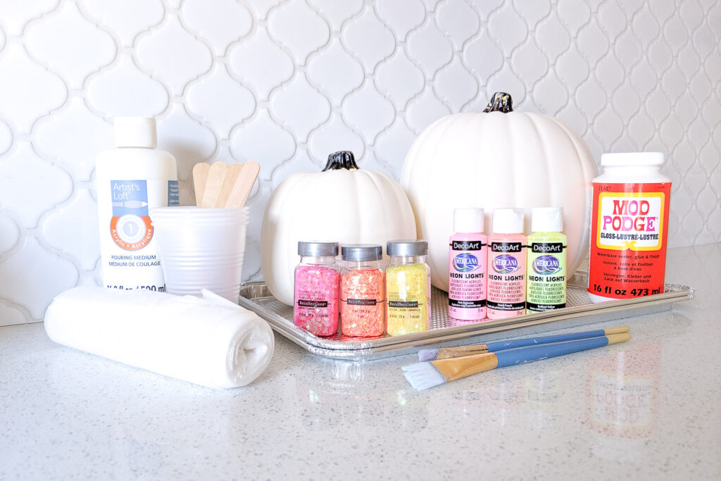 Materials needed for paint pour pumpkins.