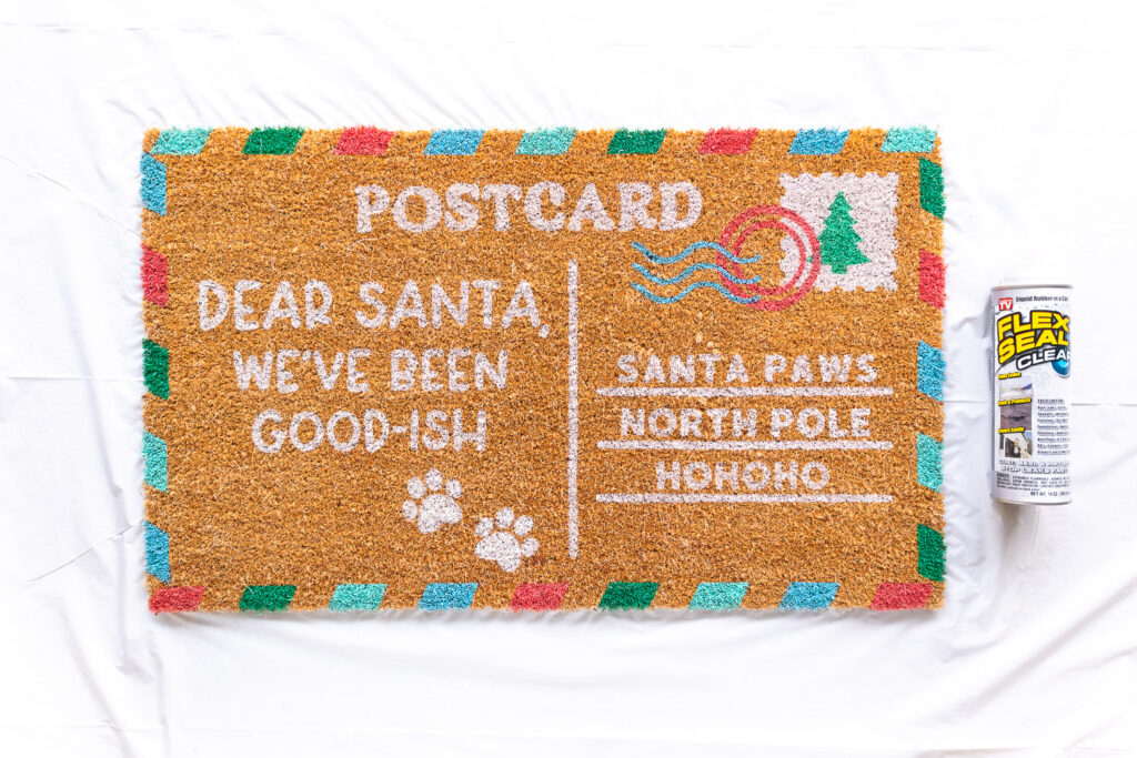 Completed postcard doormat with a bottle of Flex seal to the right.