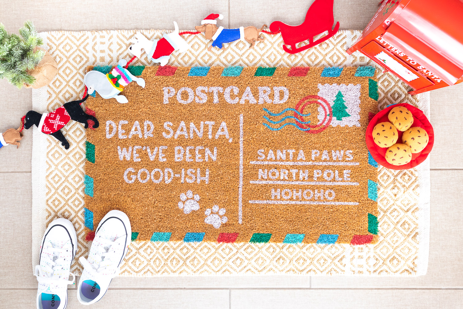 Handmade Christmas postcard doormat. The left side says "Dear Santa, We've been good-ish". The right side says "Santa Paws, North Pole, Hohoho".