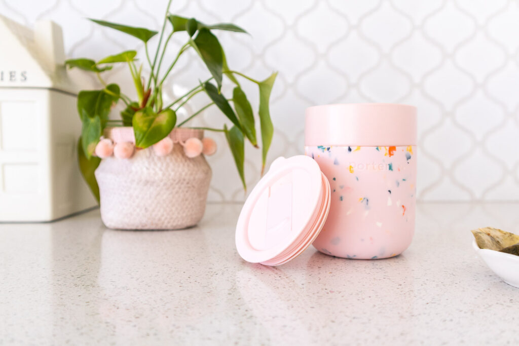 W&P pink terrazzo travel mug sitting on white kitchen counter top.