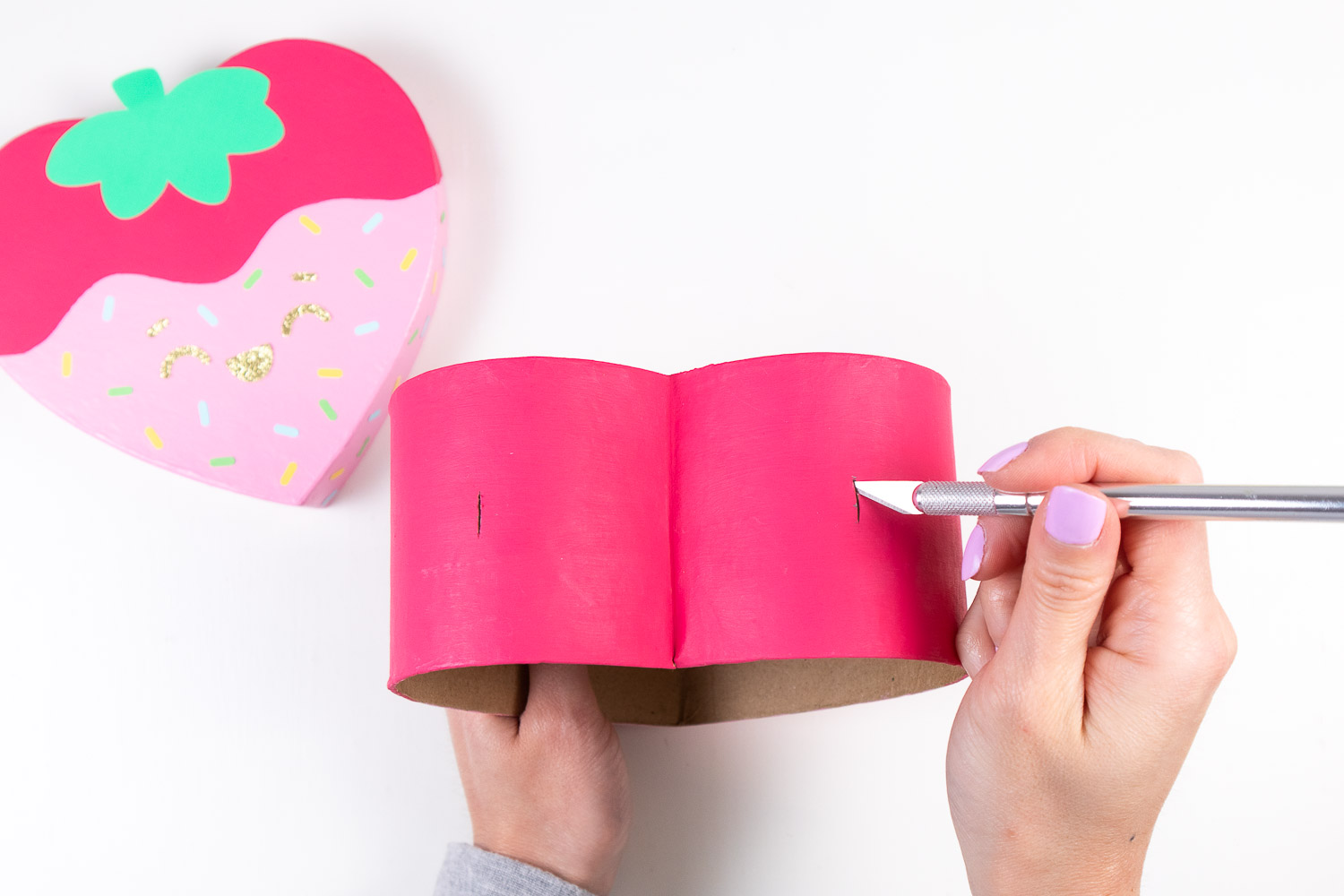 Cutting slits in the top of the heart box using craft knife. 