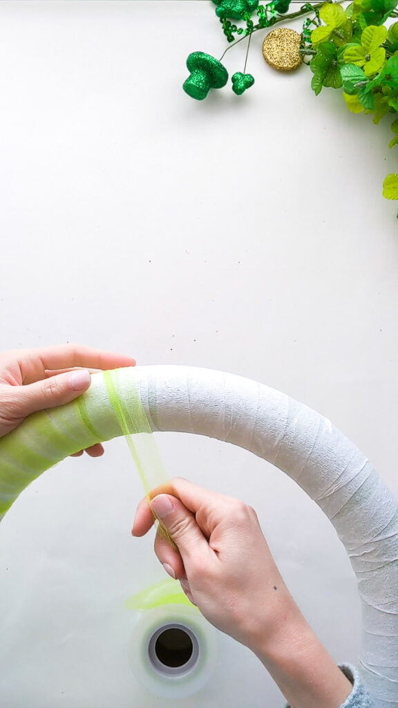 Wrapping lime green tulle around shamrock wreath.