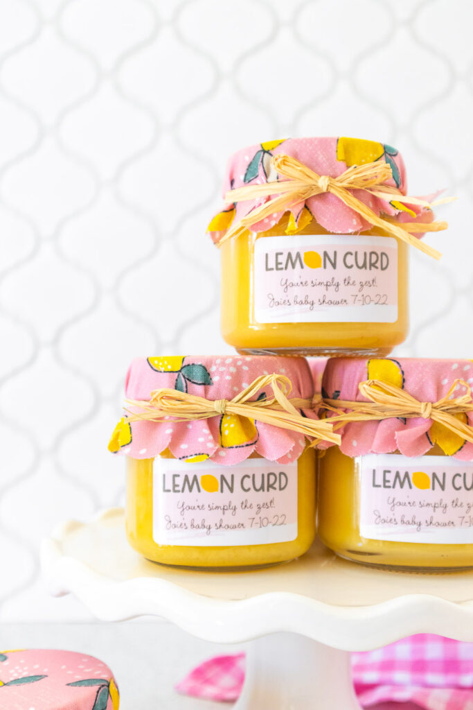 A close up of lemon curd jars with pink lemon print fabric jar covers and custom labels.