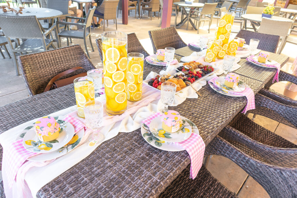 Lemon baby shower guest table with lemon centerpieces and lemon place settings.