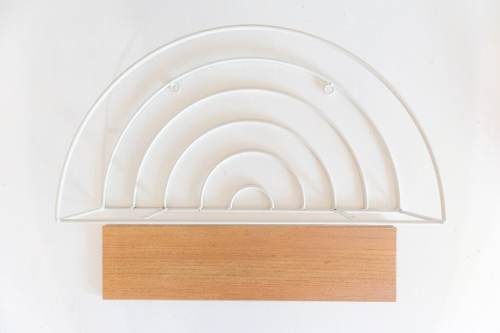 A white wire rainbow shelf is disassembled so the wire part is separated from the wood shelf base.