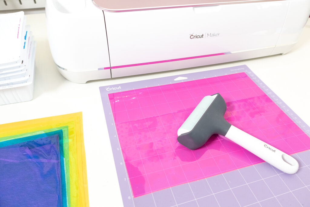 Using a brayer to stick PVC vinyl onto Cricut cutting mat.