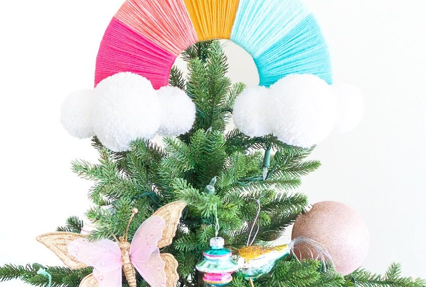 Rainbow Christmas tree topper made from colored yarn and giant white pom poms.